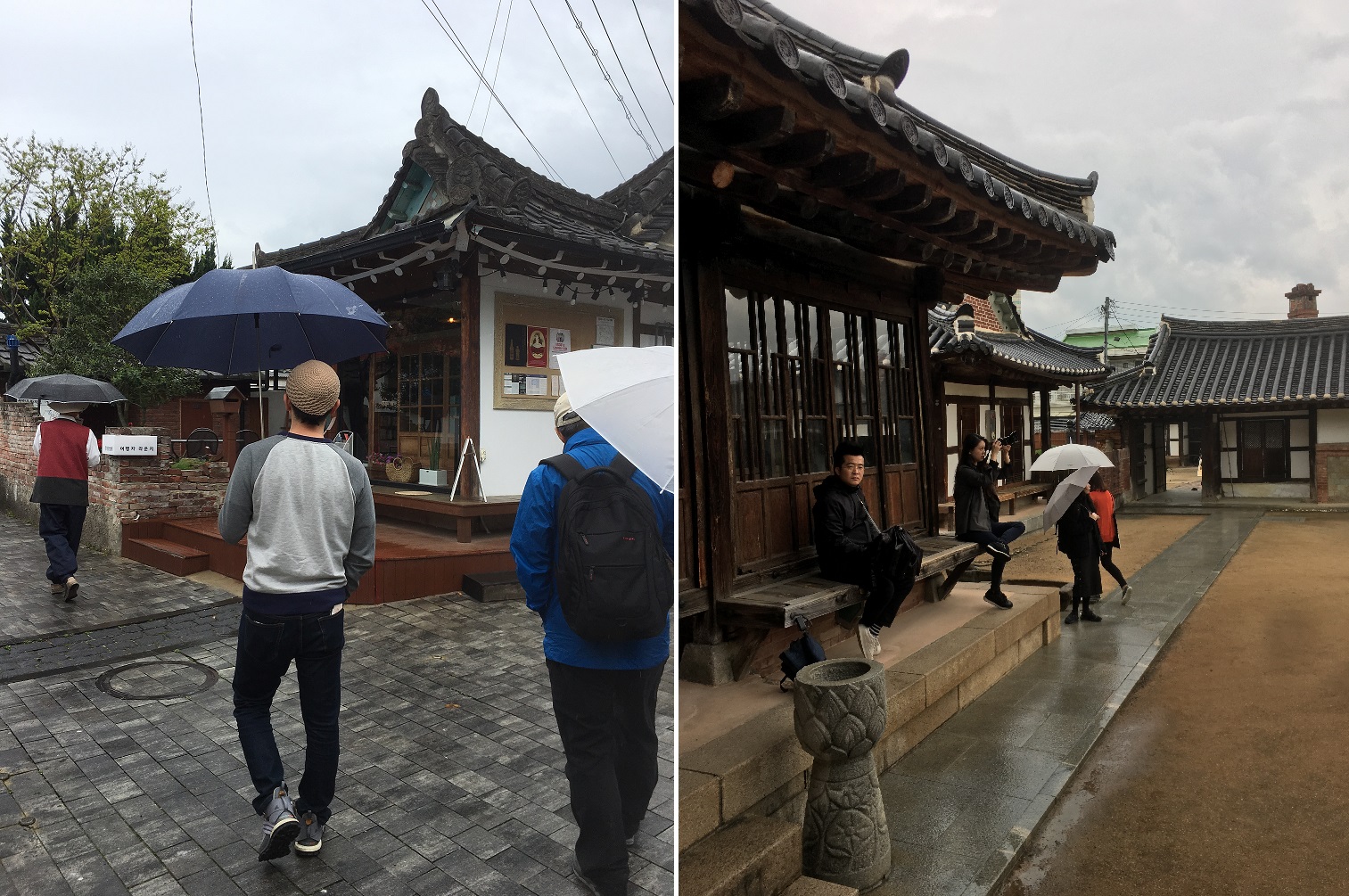 People with umbrellas walk through traditional Korean buildings