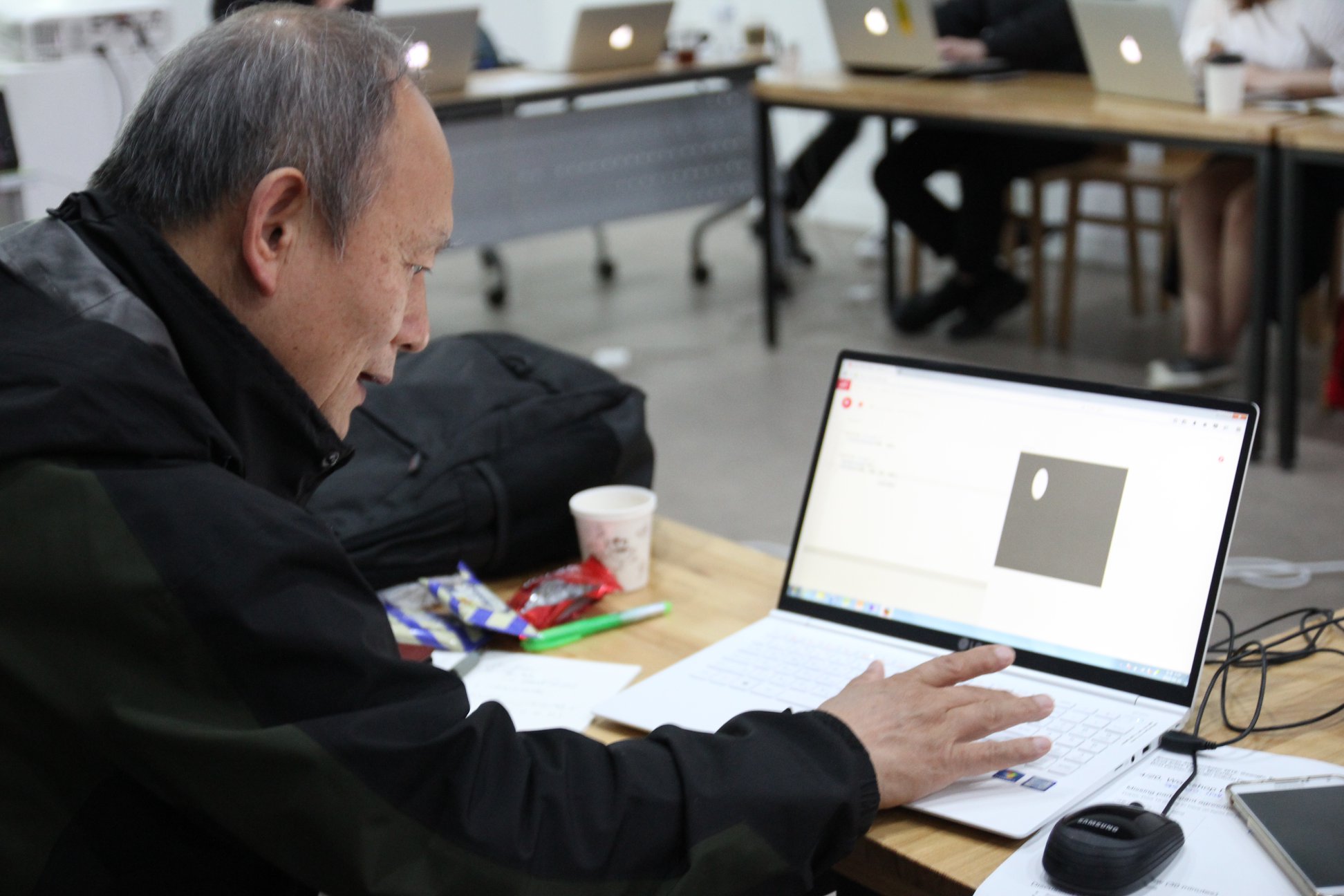 Man looks at computer screen creating a circle with code